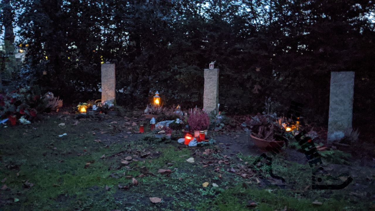 Grablichter auf gepflegten Gräbern